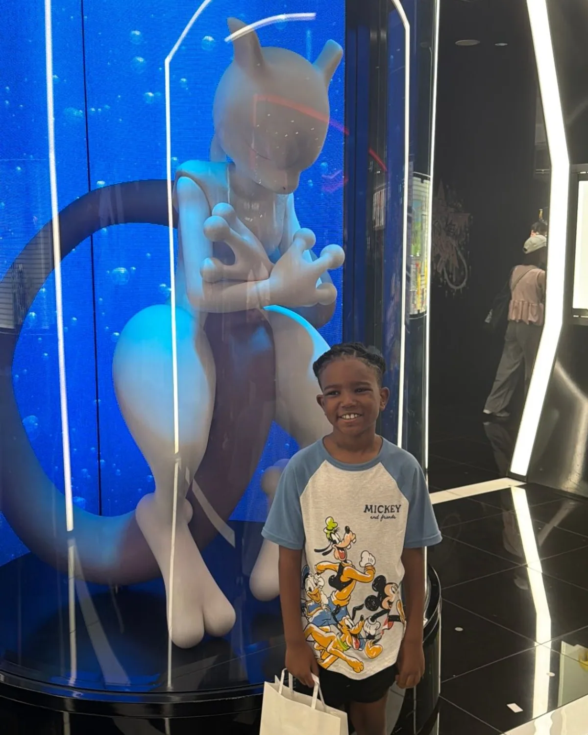 Cruz smiling beside a blue-lit character display