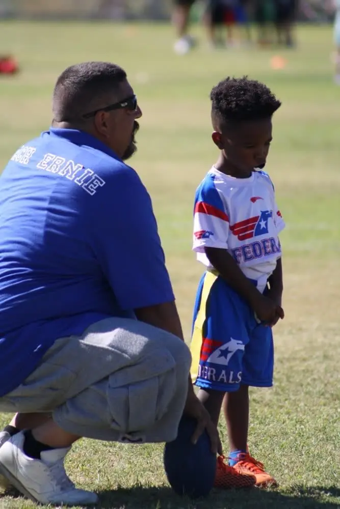 Flag football coach talking with a young player after practice