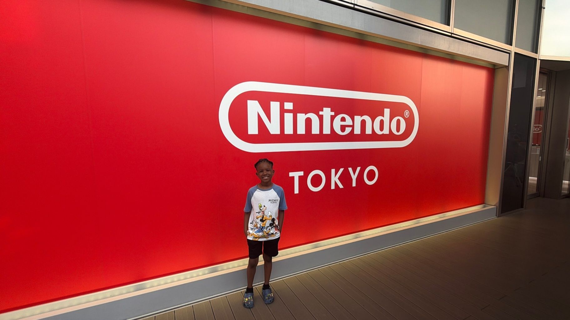 Cruz smiling in front of the Nintendo Tokyo sign in Japan